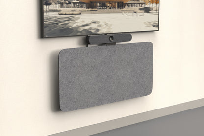 Heckler Credenza Neo in gray acoustic felt, angled view beneath a wall-mounted display and video bar — slim wall-mounted AV credenza for offices and meeting rooms.